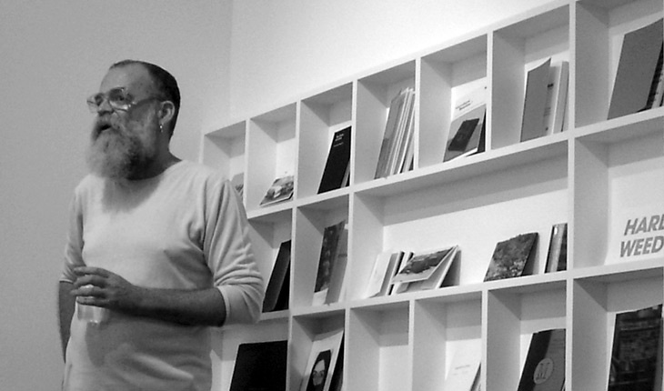 AA Bronson speaking at his exhibition Learn to Read Art: A History of Printed Matter at Artspeak, Vancouver.